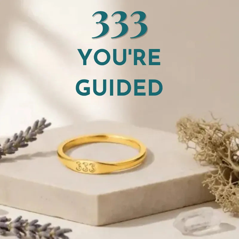 Gold bracelet with '333' engraving on a neutral background with text '333 YOU'RE GUIDED'.
