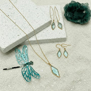 Jewelry set with earrings and a necklace on a textured surface