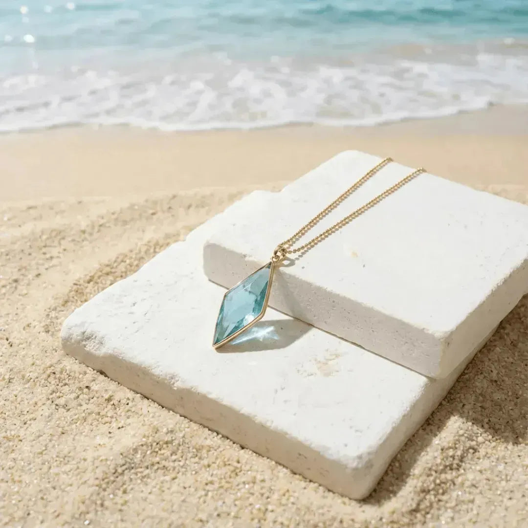 Necklace with a blue pendant on a white stone by the beach