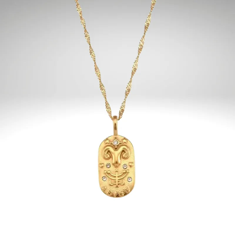 Gold necklace with a decorative pendant on a light gray background