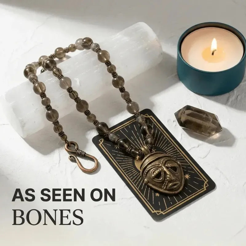 Necklace with pendant on a card next to a candle and crystal on a light surface