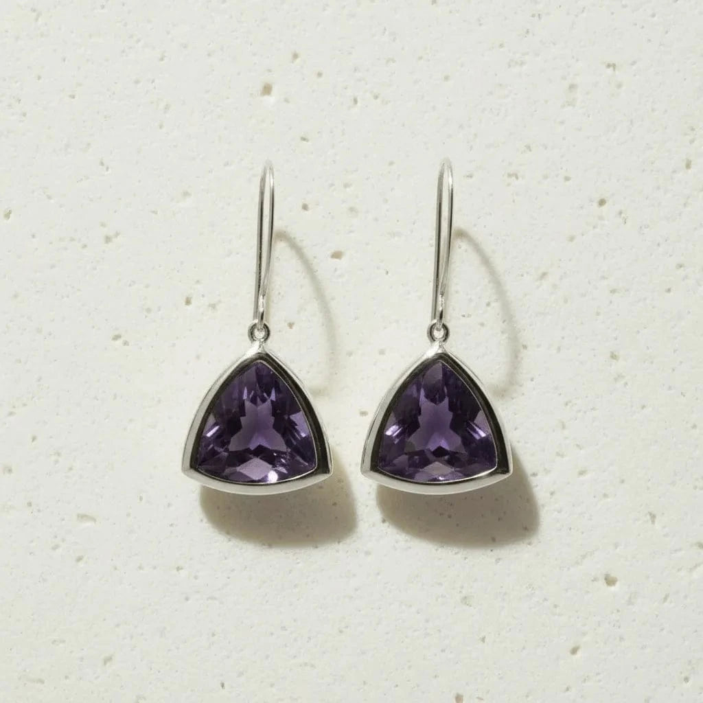 Trillion-shaped purple gemstone earrings on a light background