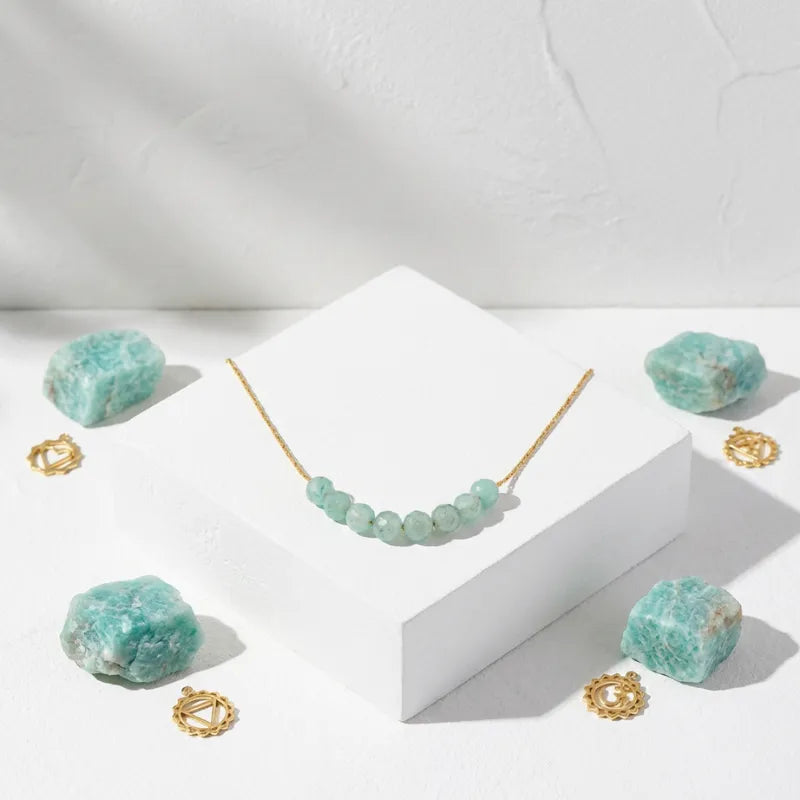 Necklace with green beads and gold clasps on a white surface