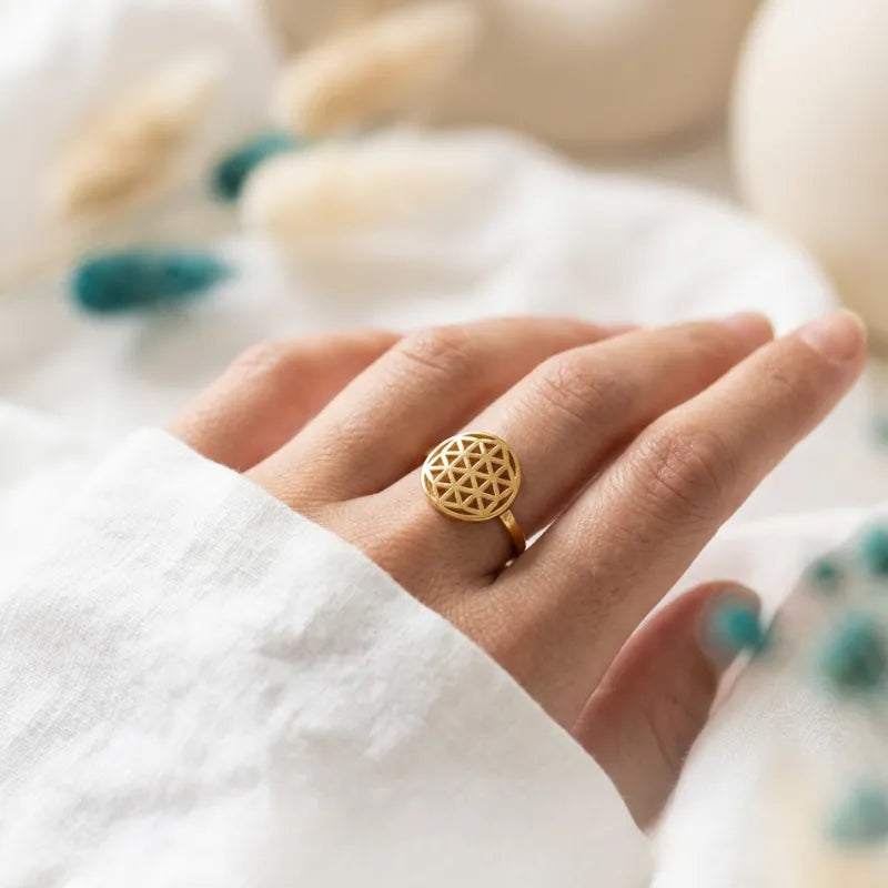 Gold flower of life ring worn on the middle finger — sacred geometry jewelry for balance