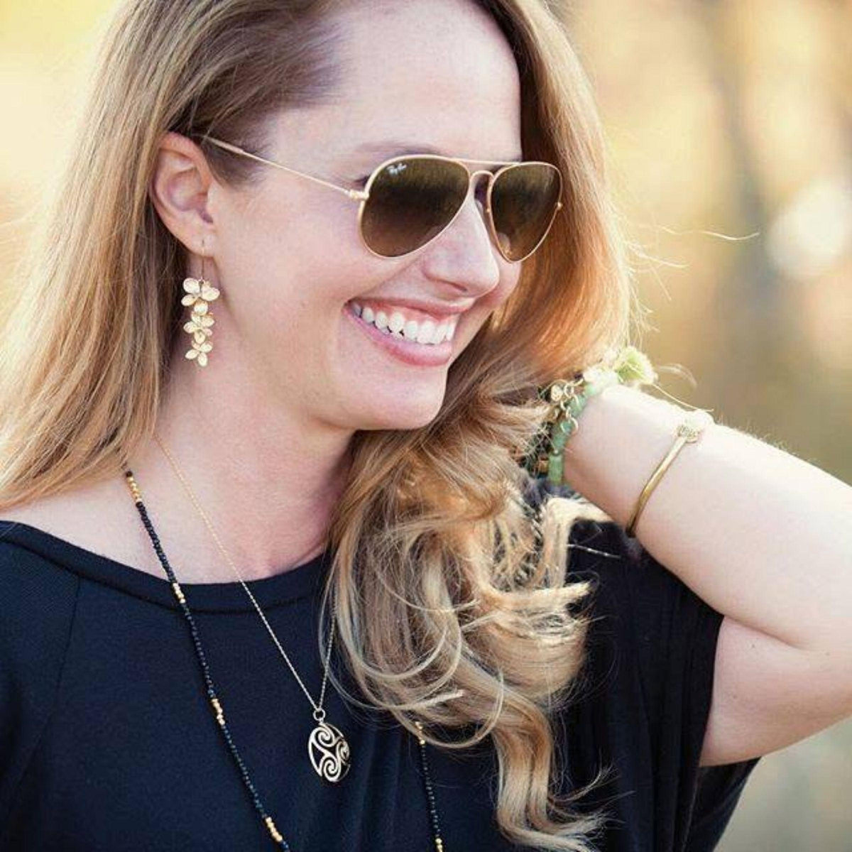 Andrea wearing Maori and Plumeria earrings she designed years ago and still sells today at Mystic Soul Jewelry