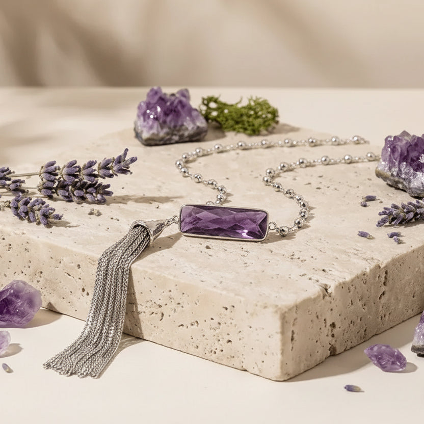 Amethyst tassel necklace on a stone surface with lavender flowers and amethyst crystals, branded as Mystic Soul Jewelry.