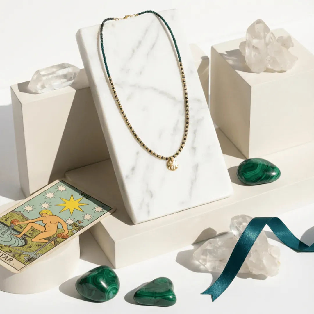 Necklace on a white stand with crystals and a Tarot card on a light background