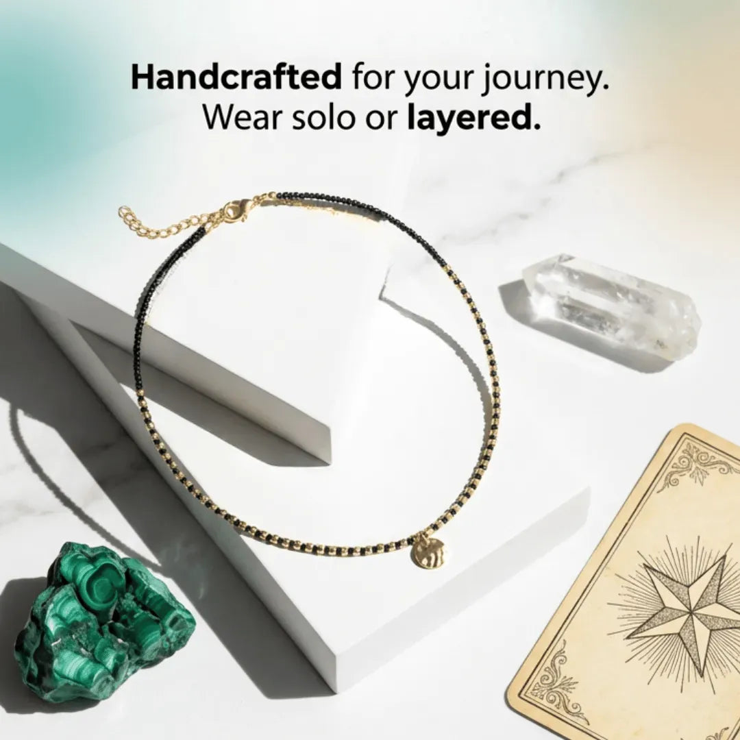 Necklace with text 'Handcrafted for your journey. Wear solo or layered.' on a white surface with crystals and a card.