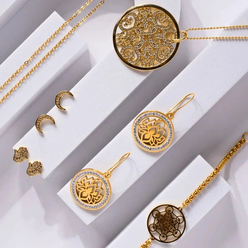 Gold jewelry set including necklaces and pendants on a white background