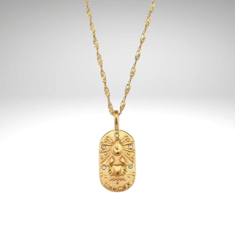 Gold necklace with a pendant on a light gray background