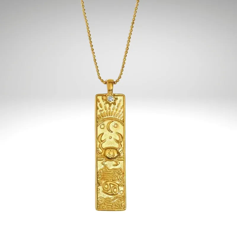 Gold pendant necklace with intricate design on a gray background