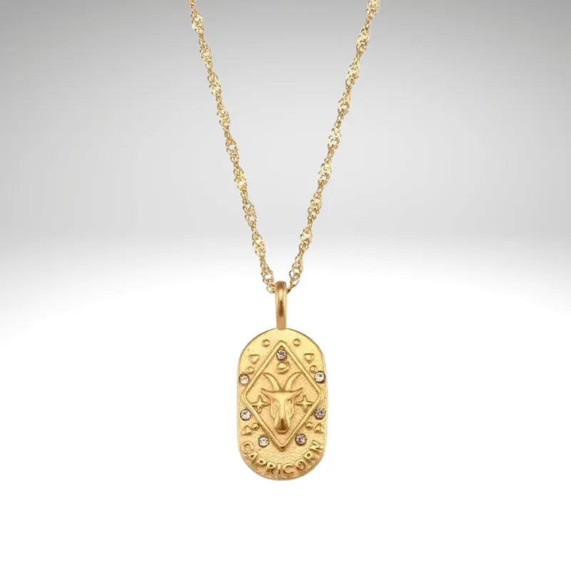 Gold necklace with a decorative pendant on a light gray background