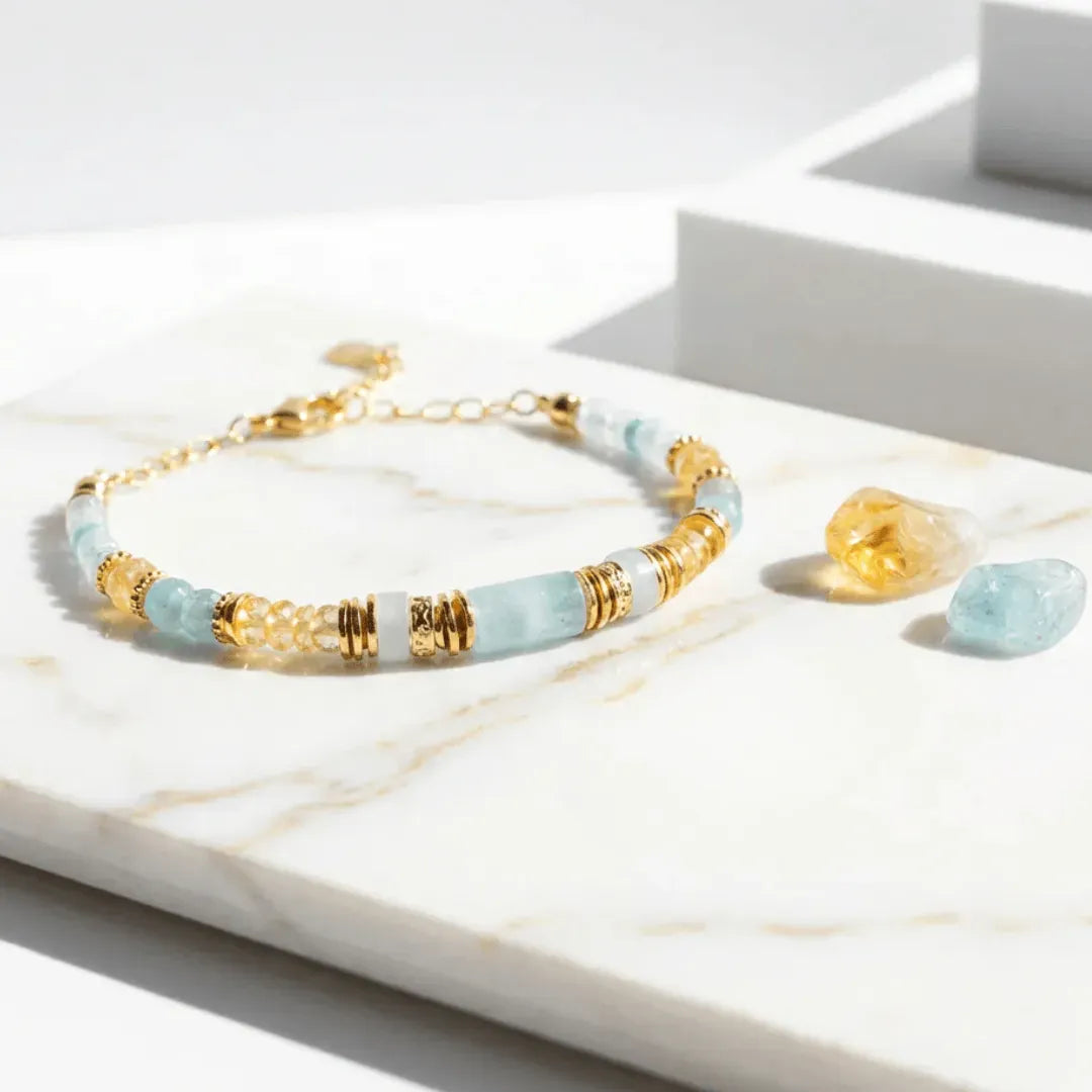 Bracelet with gold and light blue beads on a marble surface