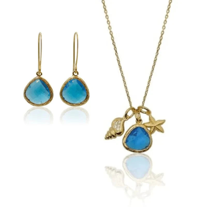 Jewelry set with blue stones and gold accents on a white background