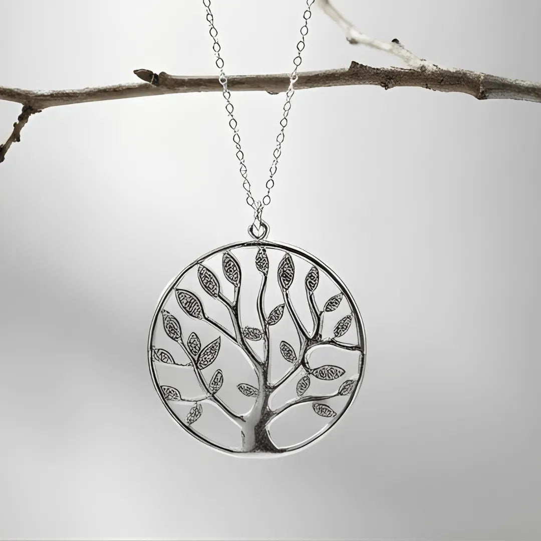 Silver tree-shaped pendant on a chain against a light gray background