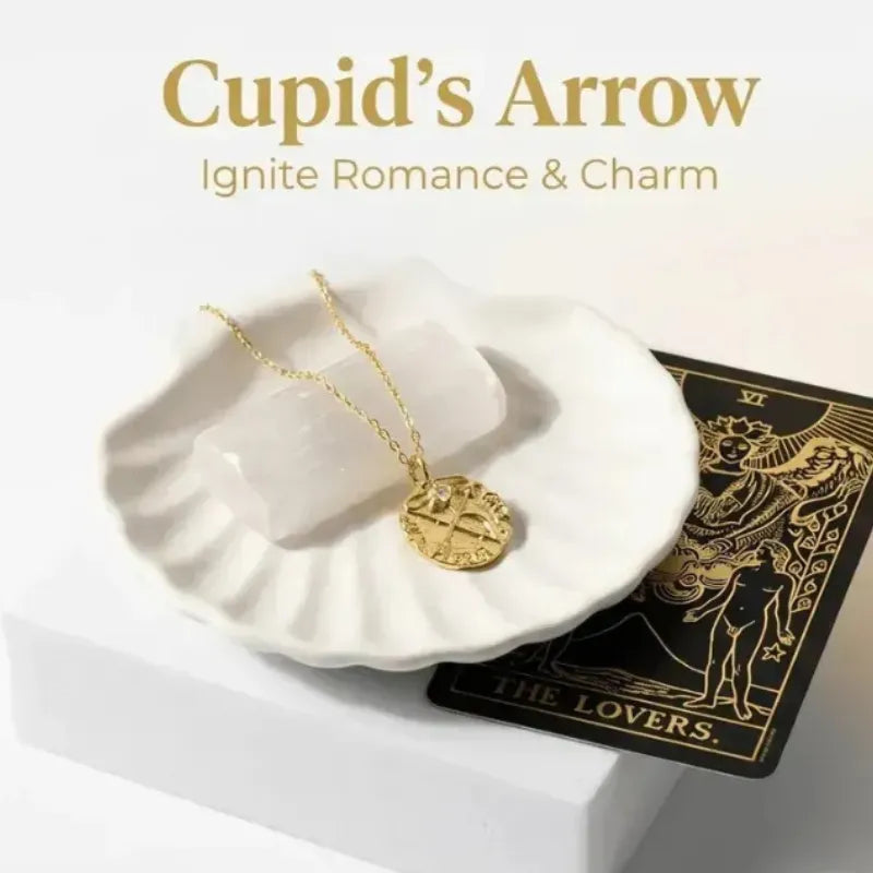 Gold necklace on a white dish with 'Cupid's Arrow' text and tarot card in the background