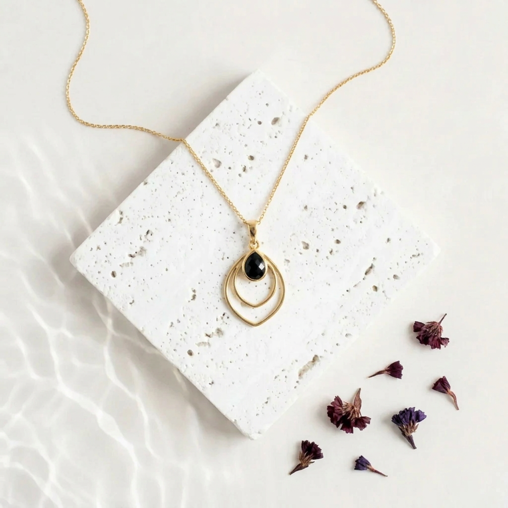 Gold Double Teardrop necklace with a black faceted glass drop inside the open frame
