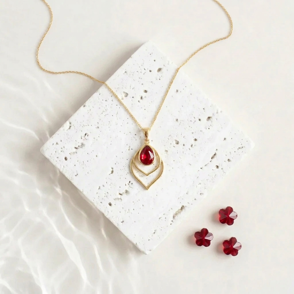 Gold Double Teardrop necklace with a red faceted glass drop inside the open frame