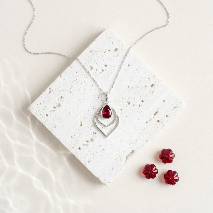 Silver Double Teardrop necklace with a red faceted glass drop inside the open frame, July birthstone colour