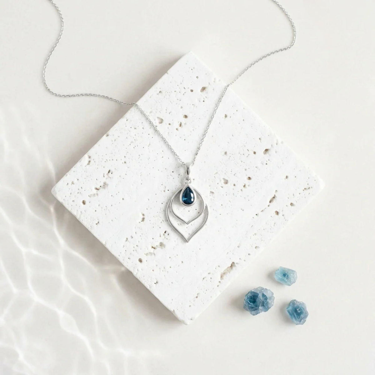 Silver Double Teardrop necklace with a sapphire blue faceted glass drop inside the open frame, September birthstone colour