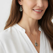 Woman wearing dusk grey exquisite necklace and earrings in silver, celestial jewelry