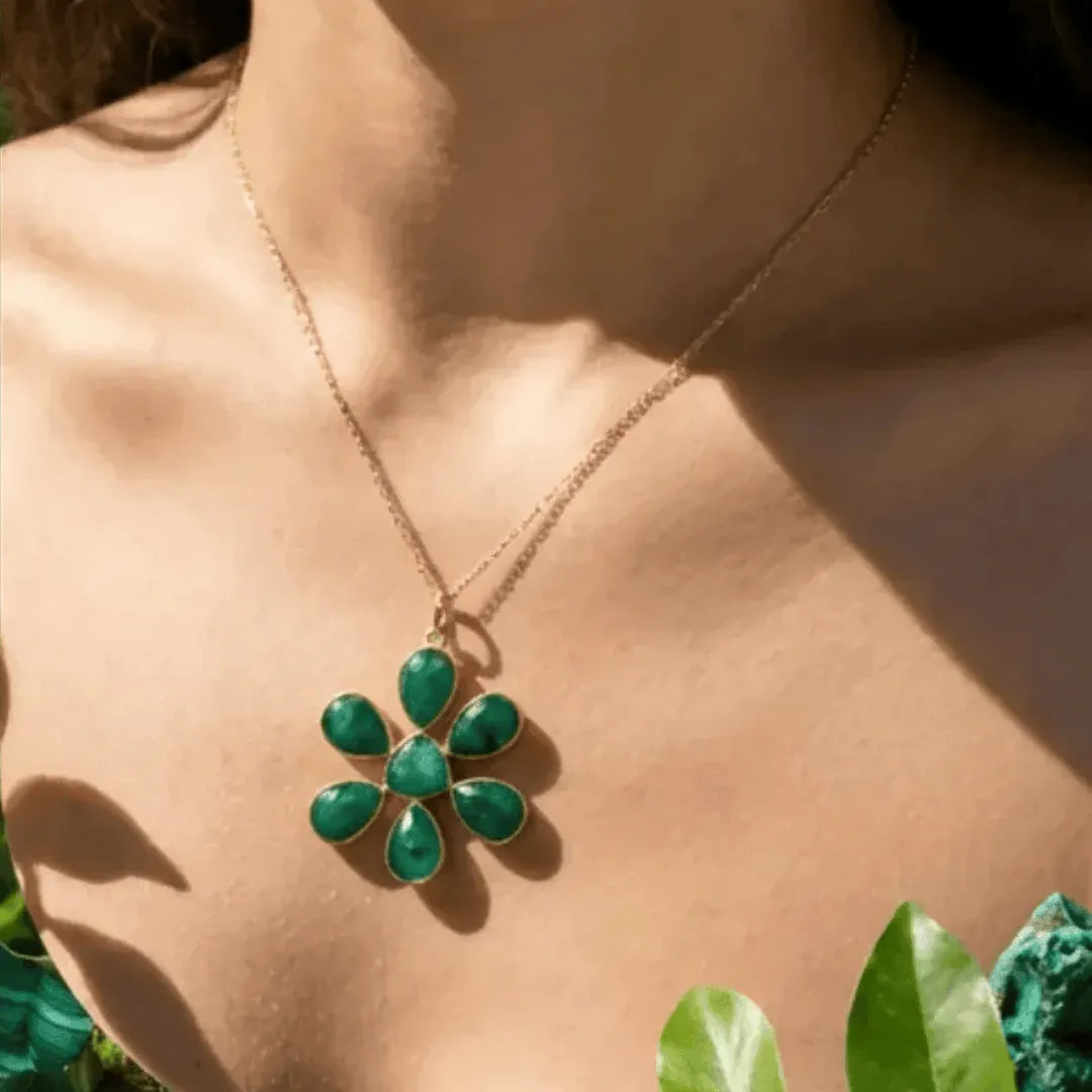 Green floral necklace on a person with green leaves in the background