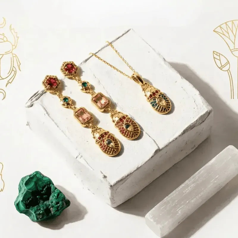 Gold jewelry set with gemstones on a white surface