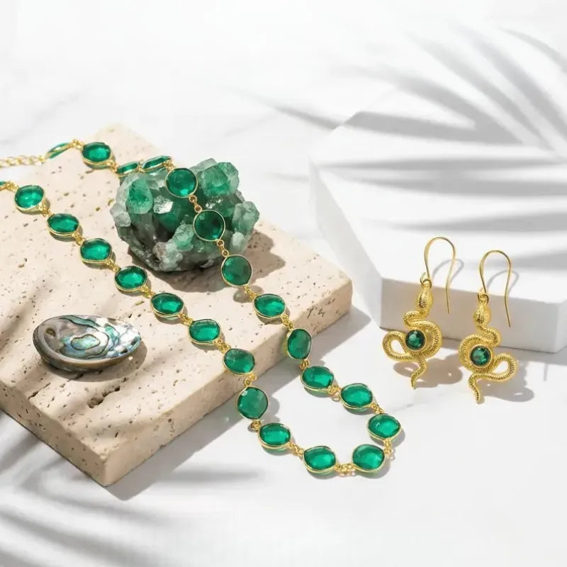 Green gemstone jewelry set with necklace and earrings on a textured surface