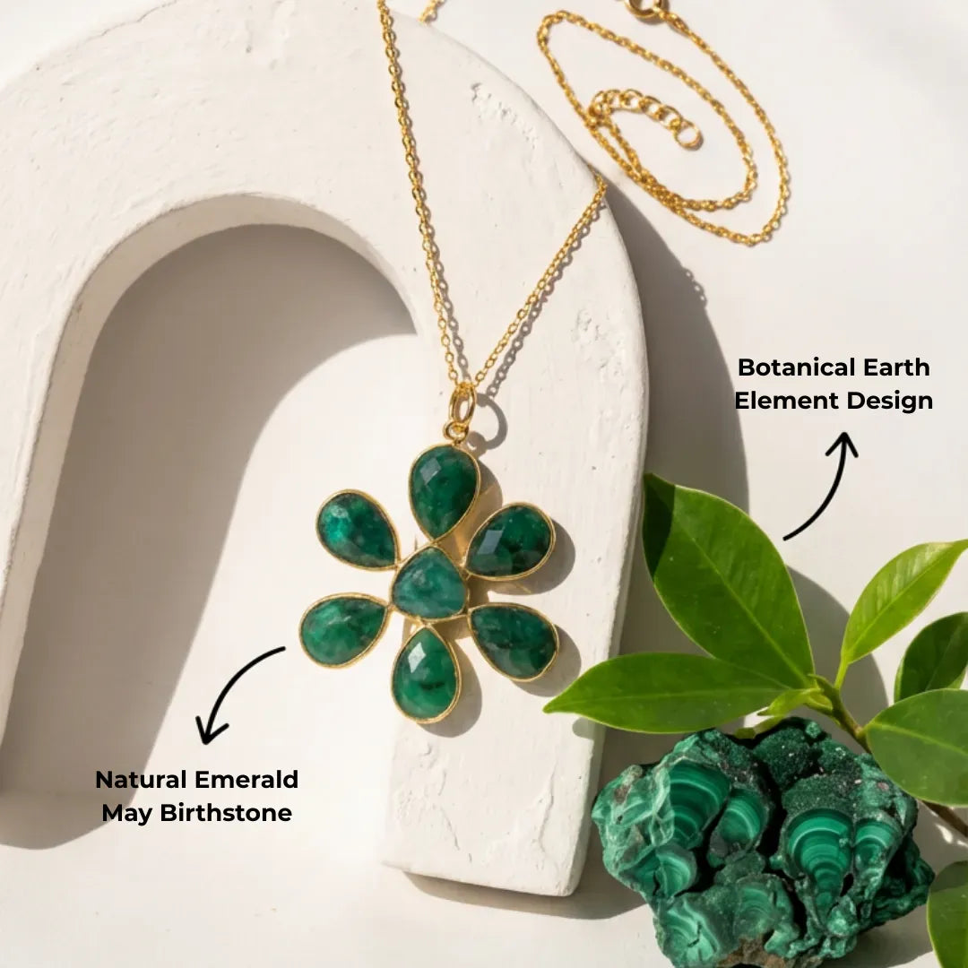 Gold necklace with a green pendant on a white surface with green crystals and leaves in the background, text 'Strength, Clarity, & Protection' above.