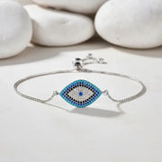 Silver bracelet with a blue and black eye design on a light background