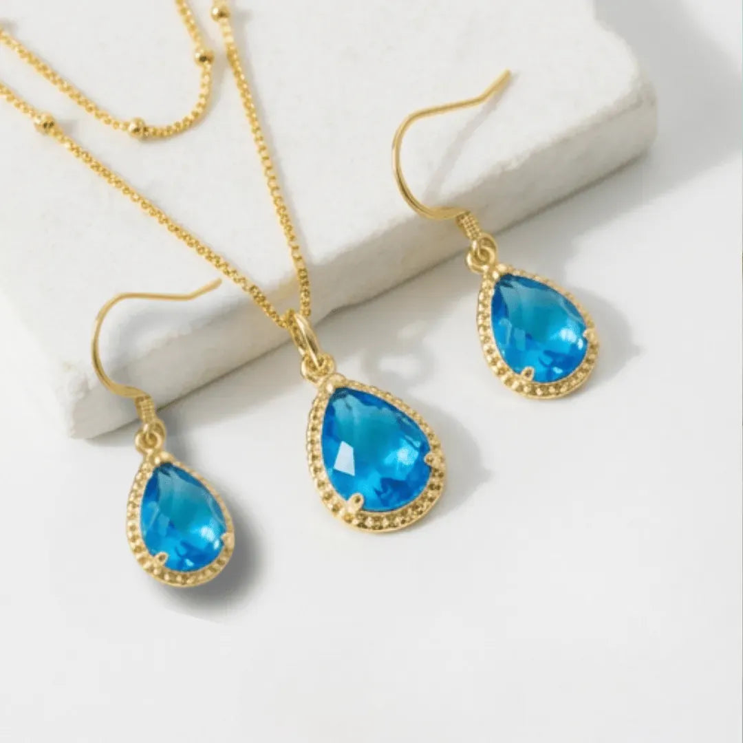 Necklace with a blue teardrop pendant on a white surface