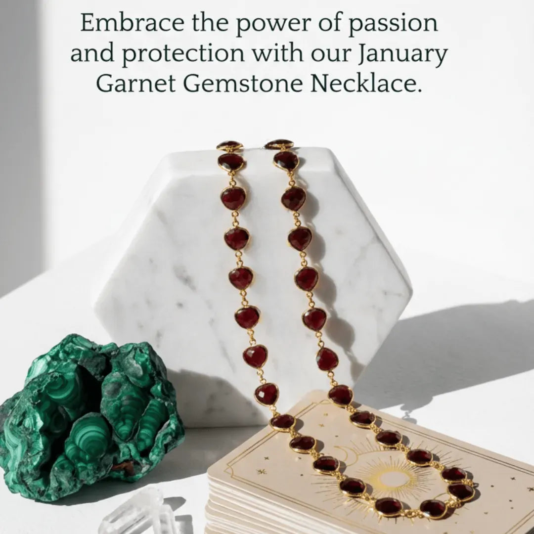 Necklace with maroon beads and gold accents on a marble stand, surrounded by crystals and tarot cards.