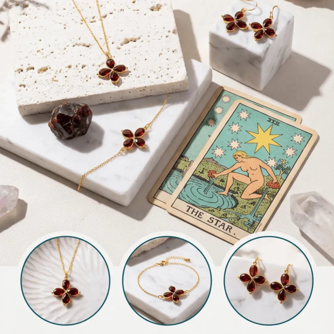 Jewelry set with gemstone pendant, necklace, and earrings on a marble surface with tarot card and crystal.