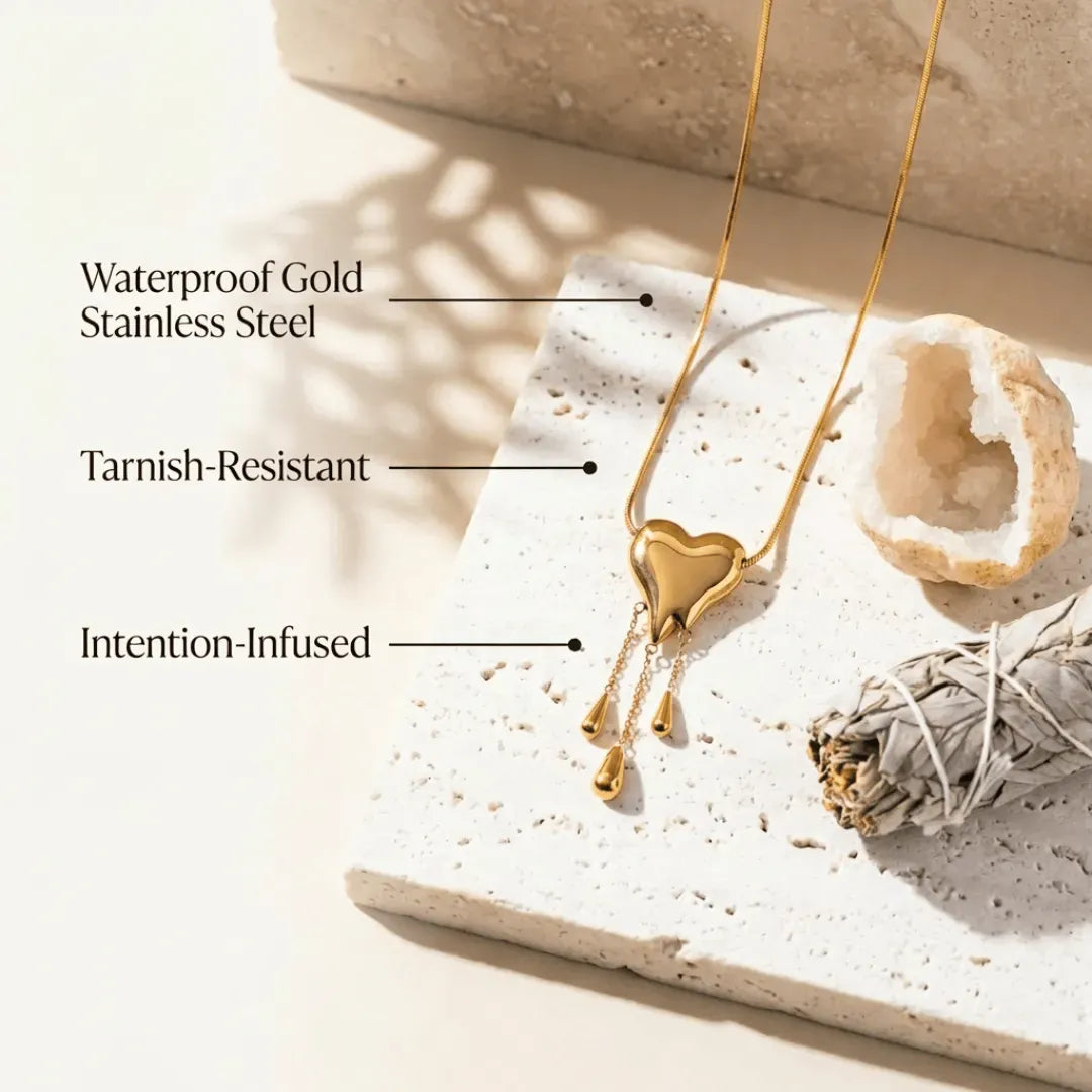 Gold necklace with heart pendant on a textured surface, labeled for material features.