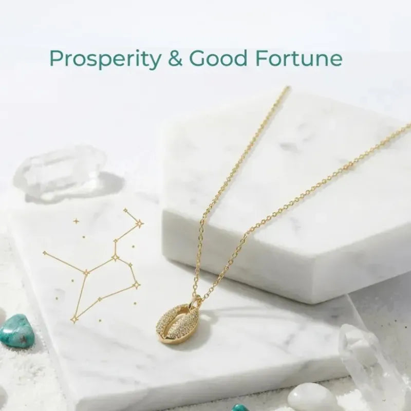 Gold necklace with shell pendant on a white surface, text 'Prosperity & Good Fortune' above.