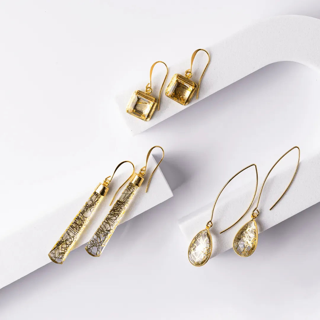 Set of gold earrings on a white background