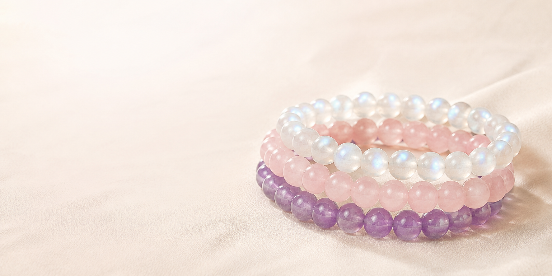 Crystal bracelet stacks banner showing moonstone, rose quartz, amethyst and clear quartz stretch bracelets