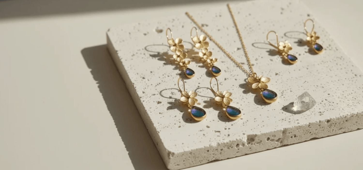 Gold jewelry set with blue stones on a textured stone surface