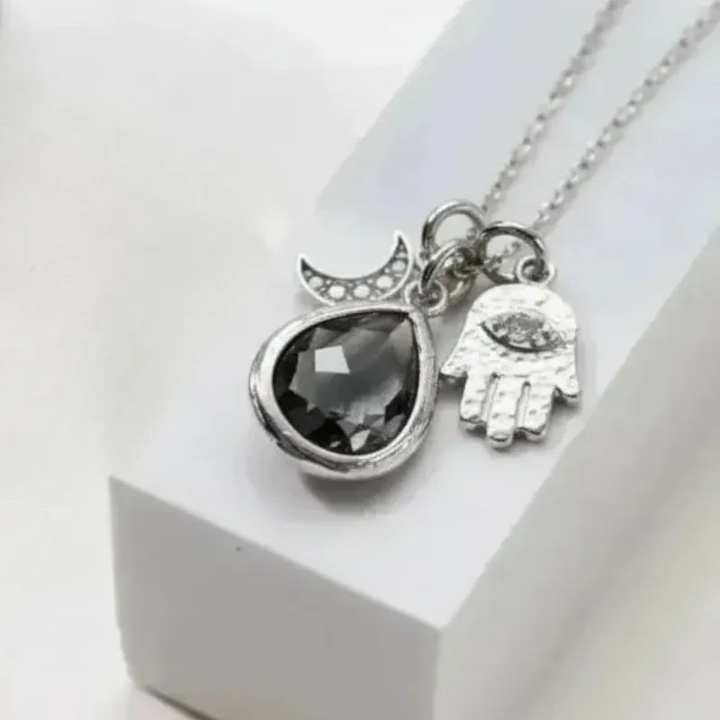 Silver plated hamsa hand and crescent moon necklace with dusk grey glass teardrop pendant
