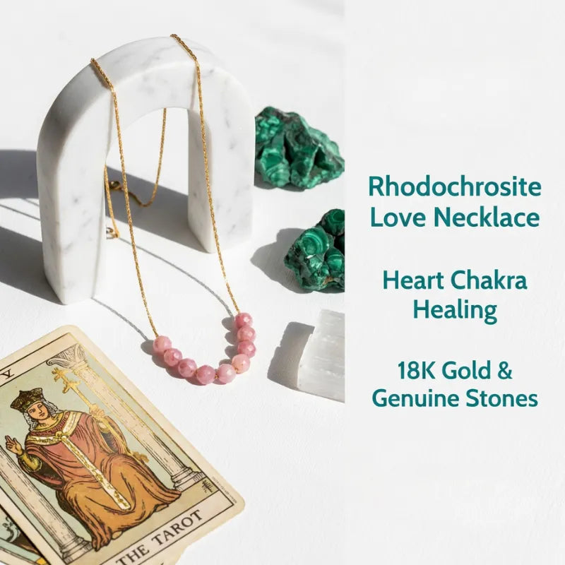Rhodochrosite Love Necklace with 18K gold and genuine stones on a white surface with tarot card and crystals.