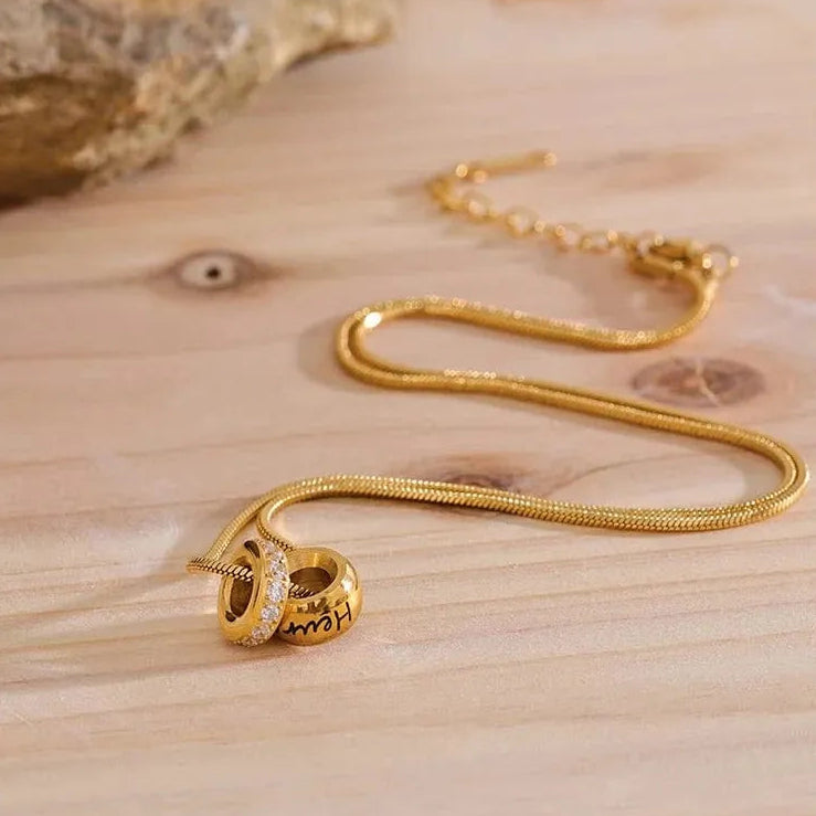 Gold necklace with a pendant on a wooden surface