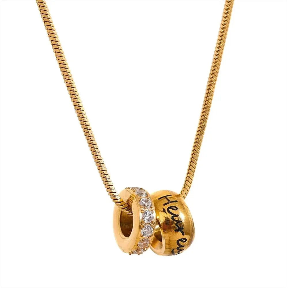 Gold necklace with two interlocking pendants on a white background