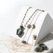 Necklace with pendant and stones on a white surface with geometric design