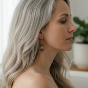 woman wearing gold labradorite, moonstone and pyrite drop earrings — one-of-a-kind crystal jewelry for grounding