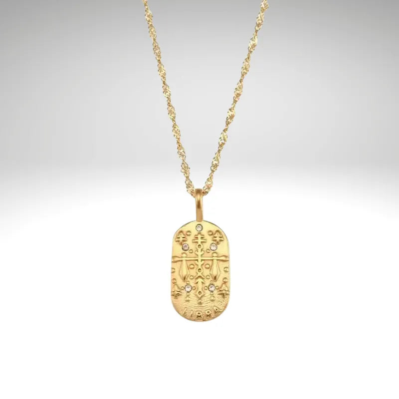 Gold necklace with a pendant on a light gray background