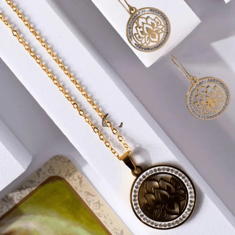 Gold necklace with intricate pendant on a white surface