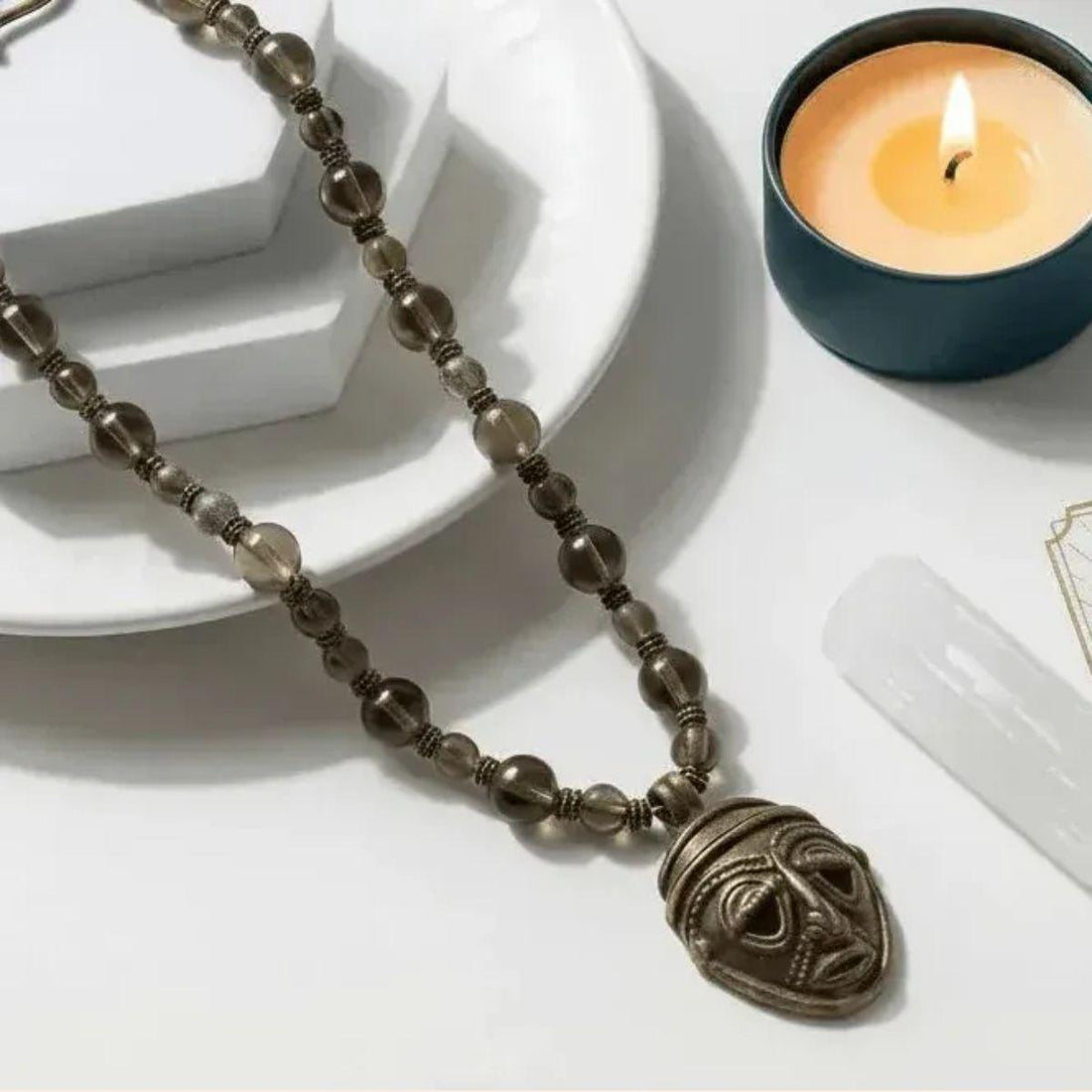 BONES_the_masks_we_wear_as_seen_on_tv_necklace on white background with candle