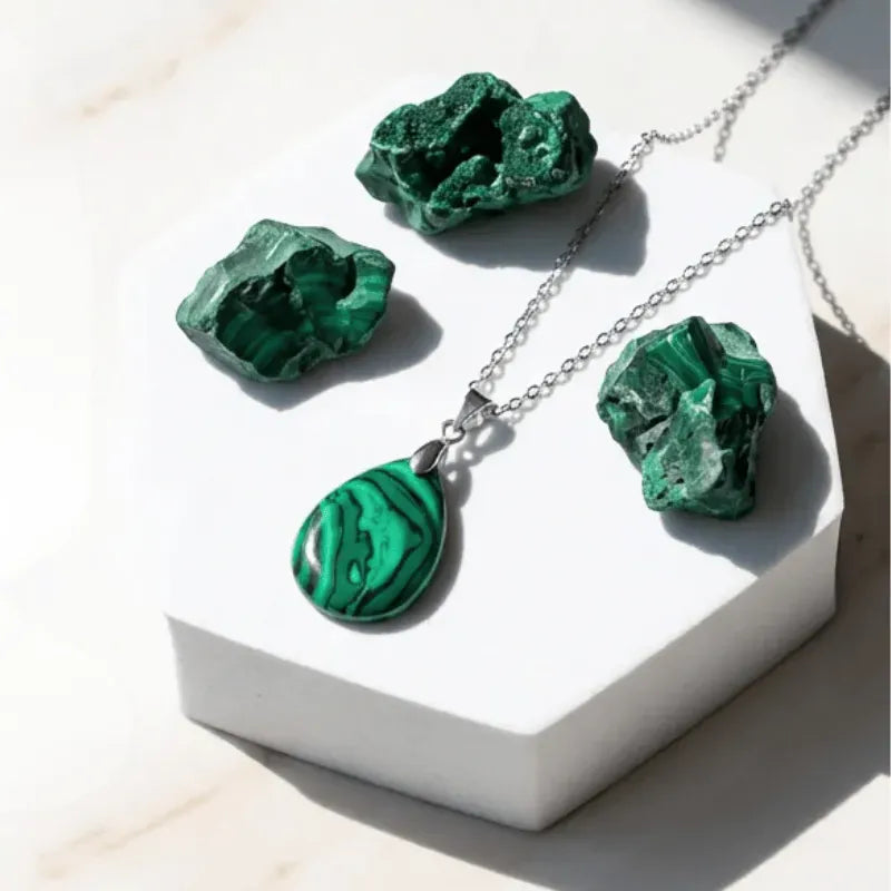 Malachite necklace and earrings on a white stand with malachite stones.