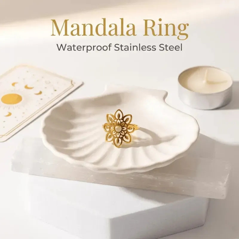 Gold mandala ring on a white dish with a white candle and card in the background