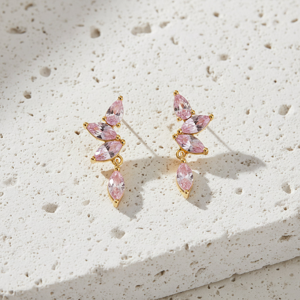 Pink marquise-shaped earrings with gold accents on a white background